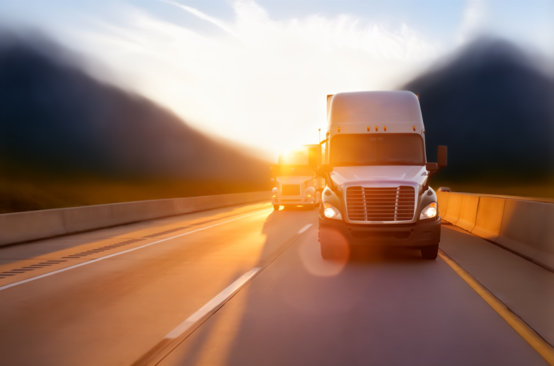 Bedrock Logistics trucks on highway at sunset